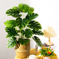 Artificial tropical tree with large leaves of decorative monstera