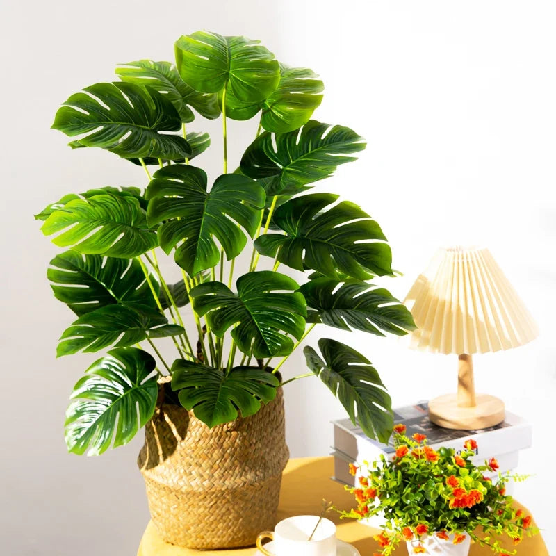 Artificial tropical tree with large leaves of decorative monstera